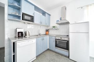 a kitchen with white appliances and blue cabinets at Apartments Martom in Seline
