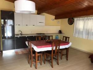 una cucina con tavolo e sedie e una cucina con lavandino di Villa Alessio a Decimomannu