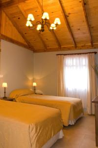 a bedroom with two beds and a window at Confin Patagonico in El Chalten