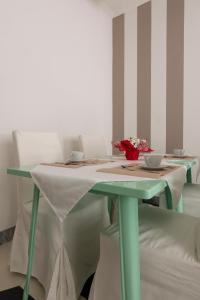 a table with two chairs and a table with two bowls on it at Merlo d'Oro in Carrara