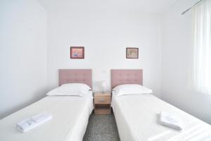 two twin beds in a room with white walls at Apartments Martom in Seline