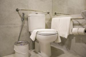 a bathroom with a white toilet and towels at Slaviero Campina Grande in Campina Grande
