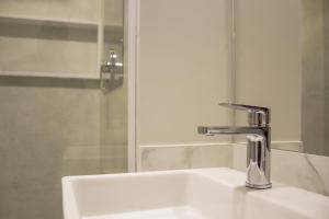a bathroom sink with a faucet and a shower at Slaviero Campina Grande in Campina Grande