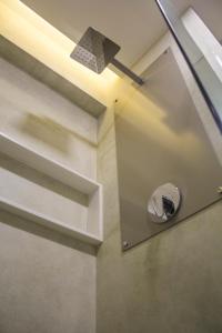 a bathroom with a mirror and a light on the wall at Slaviero Campina Grande in Campina Grande