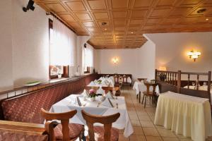 una sala da pranzo con tavoli e sedie bianchi di Landgasthof & Hotel KRONE Eischleben a Ichtershausen
