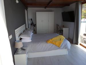 a bedroom with a white bed with a yellow blanket at Ático Los Lomos in El Paso