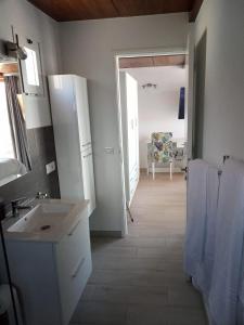 Habitación con baño con lavabo y silla. en Ático Los Lomos en El Paso