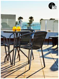 a black dining table and chairs on a balcony at Plaza de la Luz Cádiz in Cádiz