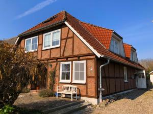 a brown house with a white chair in front of it at Tolle Ferienwohnung in schönem Bauernhaus in Fehmarn