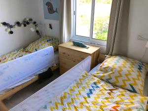 a bedroom with two beds and a window at Casa da Paz in Cedros