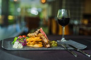 a plate of food and a glass of wine at Riande Aeropuerto Hotel Casino in Tocumen