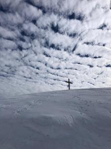 una cruz en la cima de una colina con un cielo nublado en Apartment Ape Maja, en Bad Wiessee
