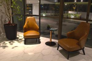 two chairs and a table in front of a window at Slaviero Campina Grande in Campina Grande
