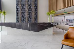 a lobby with a reception desk and a chair at Slaviero Campina Grande in Campina Grande