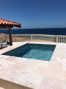 a swimming pool on a patio with the ocean in the background at The Meridian at Lighthouse Point in West Bay