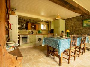 La cuisine est équipée d'une table, de chaises et d'un réfrigérateur. dans l'établissement Dolgenau Cottages, à Trefeglwys