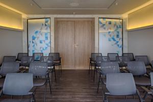 a room with rows of chairs and a wooden door at Slaviero Campina Grande in Campina Grande