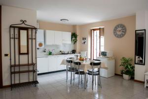 a kitchen with a table and chairs and a clock on the wall at Casa Katy in Garda