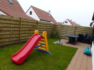 een speeltuin met een glijbaan en een tafel in een achtertuin bij Duinenhof in Middelkerke