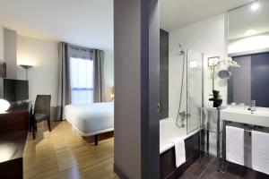 
a hotel room with a large bed and a large mirror at Exe Tres Cantos in Tres Cantos
