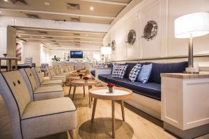 a salon with a blue couch and chairs and tables at Oro Verde Guayaquil in Guayaquil