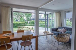 GaastmeerにあるVakantiehuis de Pondokのテーブルと椅子とソファのあるリビングルーム