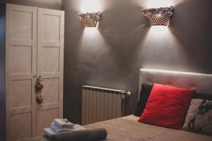 - une chambre avec un lit et deux lumières sur le mur dans l'établissement Alloggio i Geranei, à Ponte Galeria
