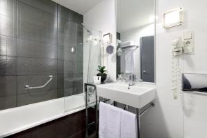 
a bathroom with a sink, mirror and bath tub at Exe Tres Cantos in Tres Cantos
