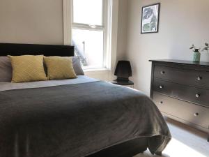 1 dormitorio con 1 cama, vestidor y ventana en Wellesley Avenue en Belfast