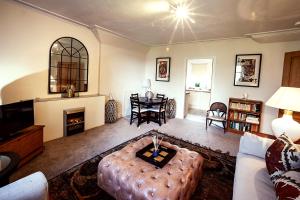 uma sala de estar com um sofá e uma mesa em Butler's Apartment. Flat 5, Dalmore House, Helensburgh, Scotland G84 8JP em Helensburgh
