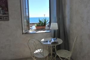 ジャルディーニ・ナクソスにあるCasa Vacanza Sweet Homeの窓のある部屋(テーブル、椅子付)