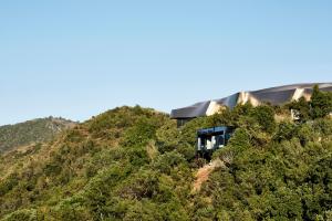 a house on top of a hill with trees at Vik Chile in San Vicente de Taguatagua