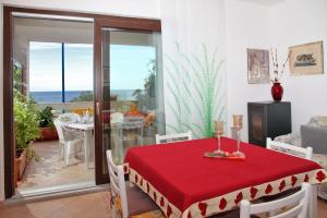 a dining room with a table with a red table cloth at Casa Pireddu in Cala Gonone