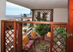 a balcony with chairs and plants and a view of the ocean at Casa Pireddu in Cala Gonone