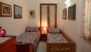 a small room with two beds and a table at Casa Pireddu in Cala Gonone