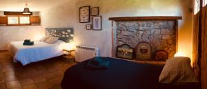 1 dormitorio con 2 camas y chimenea de piedra en Casa Azul Rodiles en Selorio