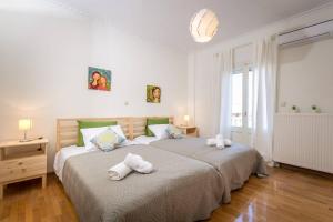 1 dormitorio con 2 camas y toallas. en Spacious Maisonette - Roof Top View of Corfu Port, en Mantoúkion