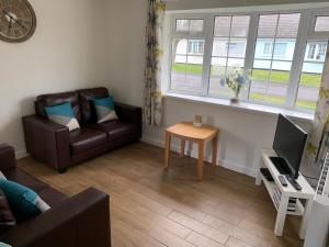 24 Gower Holiday Village في Reynoldston: غرفة معيشة مع أريكة وطاولة