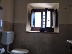 ein Bad mit einem WC und einem Fenster in der Unterkunft B&B Il Castellaro Zocca in Zocca