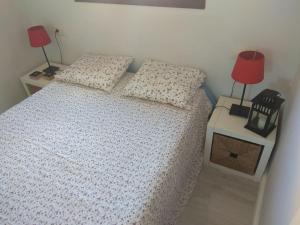 um quarto com uma cama com 2 almofadas e 2 candeeiros em A Guaira, fantástico apartamento al borde del mar em Oia