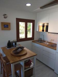 uma cozinha com uma mesa de madeira e um lavatório em A Guaira, fantástico apartamento al borde del mar em Oia