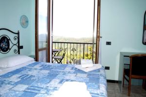 ピニョーネにあるAntiche Terre Hotel & Relaxのベッドルーム(ベッド1台付)、バルコニーが備わります。