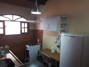 a small kitchen with a table and a refrigerator at Suíte com vista da Serra in Teresópolis