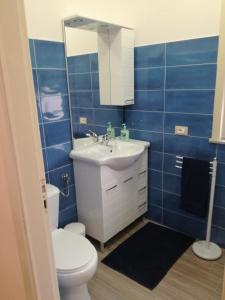 ein Badezimmer mit einem Waschbecken, einem WC und einem Spiegel in der Unterkunft Casa vacanza Petrulli in Zafferana Etnea