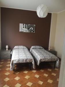 1 Schlafzimmer mit 2 Betten und einer Wand in der Unterkunft Casa vacanza Petrulli in Zafferana Etnea