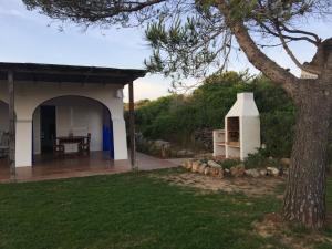 une maison avec une table et un arbre dans une cour dans l'établissement Villa Bini Roca, à Cap d'en Font