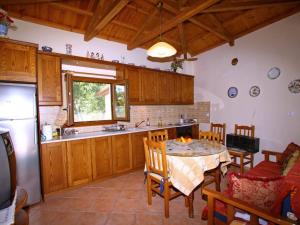 a kitchen with a table and chairs and a refrigerator at Anania Cottage in Skopelos Town