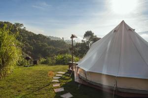 Arcabuco的住宿－Glamping Finca Corazón，坐在草地上的白色帐篷