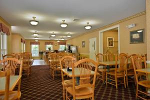 uma sala de jantar com mesas e cadeiras de madeira em Bar Harbor Grand Hotel em Bar Harbor