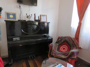 sala de estar con piano y silla en Hostal Mirenart, en Valparaíso